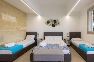 a bedroom with two beds and a brick wall at B&B Annita in Porto Cesareo