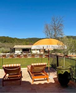 two chairs and an umbrella on a patio at Domaine Robert in Rognes