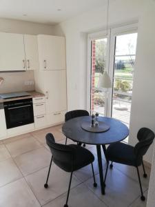 a kitchen with a table and chairs in a room at Ferienwohnung Landidyll Heese in Langlingen