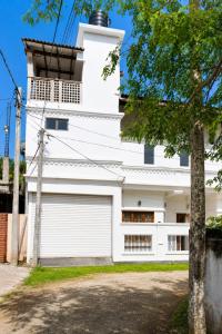 a white building with a garage at Princess Rose Villa in Vavuniya