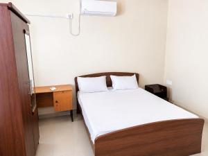 a small bedroom with a bed and a desk at Princess Rose Villa in Vavuniya