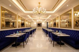 a row of tables in a restaurant with a chandelier at Hotel Tela Suite Near IGI Airport Delhi in New Delhi +21 photos