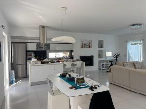a white kitchen and living room with a couch and a table at villa zakintos in Aspro Chorio Paros