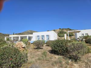 a white house with bushes in front of it at villa zakintos in Aspro Chorio Paros