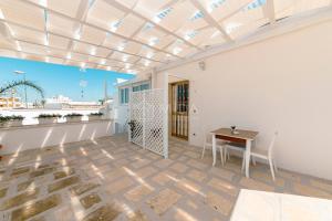 a living room with a table and a balcony at LORY'S HOUSE in Porto Cesareo