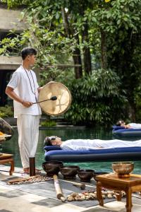 a man holding a paddle next to a man laying on a raft at The Lokha Ubud Resort, Villas & SPA in Ubud