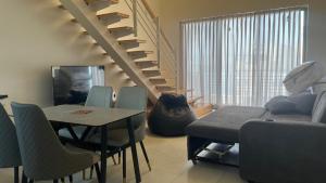 a living room with a staircase and a table and chairs at Bella by the Sea in Sowayma
