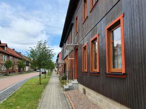 a black building with orange windows on a street at Ferienwohnung Fessel in Hasselfelde