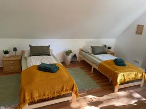 a bedroom with two beds with yellow blankets at Dorfstübli - gemütliche und ruhige Zimmer in Ortsrandlage in Alt Schönau