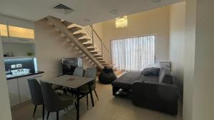 a living room with a couch and a table and a staircase at Bella by the Sea in Sowayma