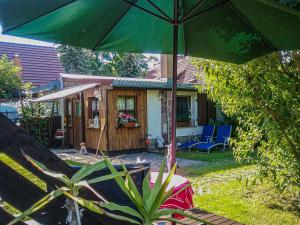 a green umbrella in front of a house at Gemütliche Ferienwohnung Löbert in Lübbenau
