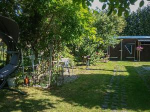 a garden with a tree and a fence at Gemütliche Ferienwohnung Löbert in Lübbenau