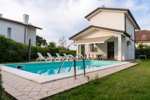 a villa with a swimming pool in front of a house at Aurora in Caleri