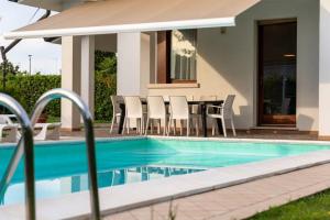 a house with a swimming pool and a table and chairs at Aurora in Caleri +23 photos