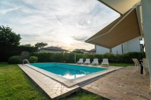 a swimming pool in a yard with chairs around it at Aurora in Caleri