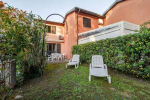two white chairs sitting in the backyard of a house at Casa 1207 in Caleri