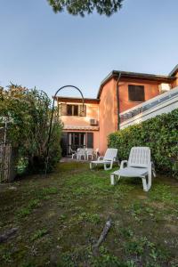 two white benches in the yard of a house at Casa 1207 in Caleri