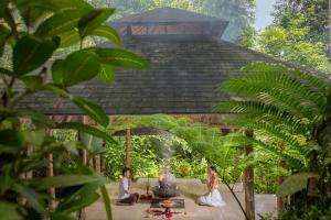 a group of people sitting under a gazebo at The Lokha Ubud Resort, Villas & SPA in Ubud