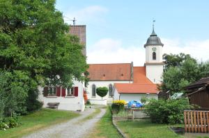 a small white church with a steeple and a street at Hofgut Bentele in Deggenhausertal