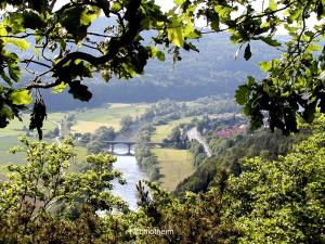 a view of a river with a bridge and trees at Ferienwohnung Hamel in Kirchlotheim