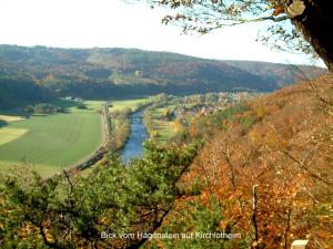 a river in the middle of a valley with trees at Ferienwohnung Hamel in Kirchlotheim