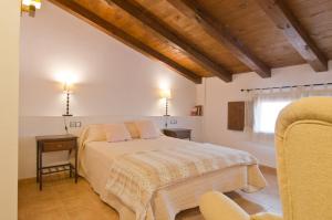 a bedroom with a bed and a table and a window at La Posada De Santa Ana in Tramacastilla