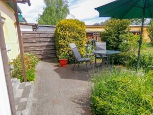 a patio with a table and chairs and an umbrella at Ferienwohnungen Sirius in Zinnowitz