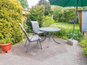 two chairs and a table and an umbrella on a patio at Ferienwohnungen Sirius in Zinnowitz