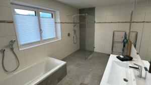a bathroom with a tub and a sink and a shower at Wild und Wald Ferienwohnung in Steinbach am Attersee