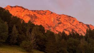 a mountain with the sun shining on it at Wild und Wald Ferienwohnung in Steinbach am Attersee