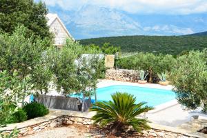 a villa with a swimming pool with mountains in the background at Holiday Home Sweet Dreams in Pučišća