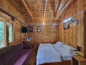 a bedroom with a bed in a wooden room at Mid Conifer Cottage Villa in Dalhousie