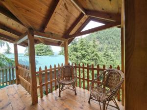 a porch with two chairs and a wooden ceiling at Mid Conifer Cottage Villa in Dalhousie
