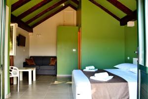 2 camas en una habitación con paredes verdes y sofá en Holiday Home Sweet Dreams, en Pučišća