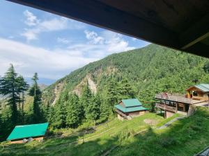 a view of a mountain with houses and trees at Mid Conifer Cottage Villa in Dalhousie +1 photo