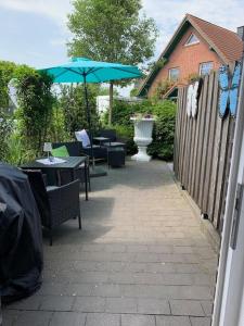 a patio with tables and chairs and an umbrella at Ferienwohnung Teutoblick Leeden in Tecklenburg