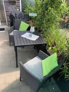 a table and chairs with green pillows on a patio at Ferienwohnung Teutoblick Leeden in Tecklenburg