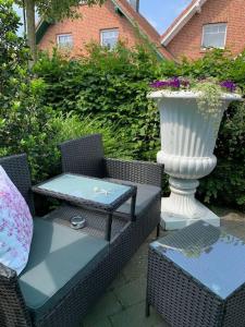 a table and chairs with a vase on a patio at Ferienwohnung Teutoblick Leeden in Tecklenburg +20 photos