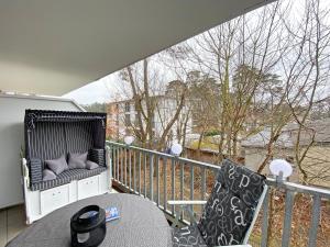 a balcony with a bench and a table and chairs at Ferienwohnung Ostseeliebe mit Balkon in Baabe