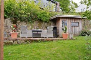 a patio with two chairs and a table in a yard at MispelFachwerkOase in Tecklenburg