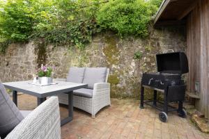 a patio with a table and a grill with a television at MispelFachwerkOase in Tecklenburg +26 photos