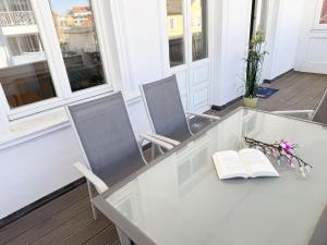 a white table with two chairs and a book at Villa Minna Whg 06 mit Balkon in Göhren
