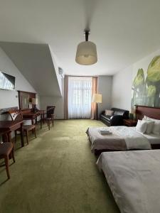 a hotel room with two beds and a dining room at Hotel Neo Międzyrzecz in Międzyrzecz