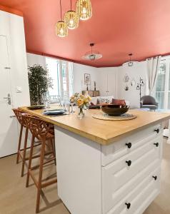 a kitchen with white cabinets and a wooden counter top at T2 lumineux, moderne, calme & central à Montargis in Montargis