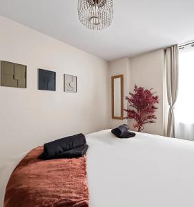 a bedroom with a large white bed and a window at T2 lumineux, moderne, calme & central à Montargis in Montargis