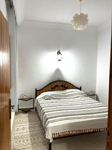 a bedroom with a large bed with a wooden headboard at Tamezda 4 in Taguermess