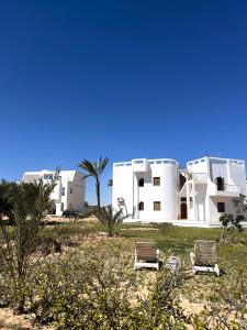 two chairs in front of some white buildings at Tamezda 4 in Taguermess