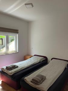 two beds sitting in a room with a window at Apartment Sole in Poreč