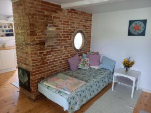 a living room with a couch against a brick wall at Hasselsro in Tranekær