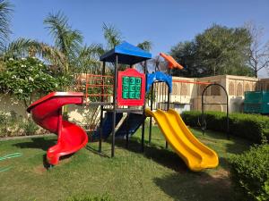 a playground with three slides in the grass at Pink Mahal Hotel & Resort in Jaipur